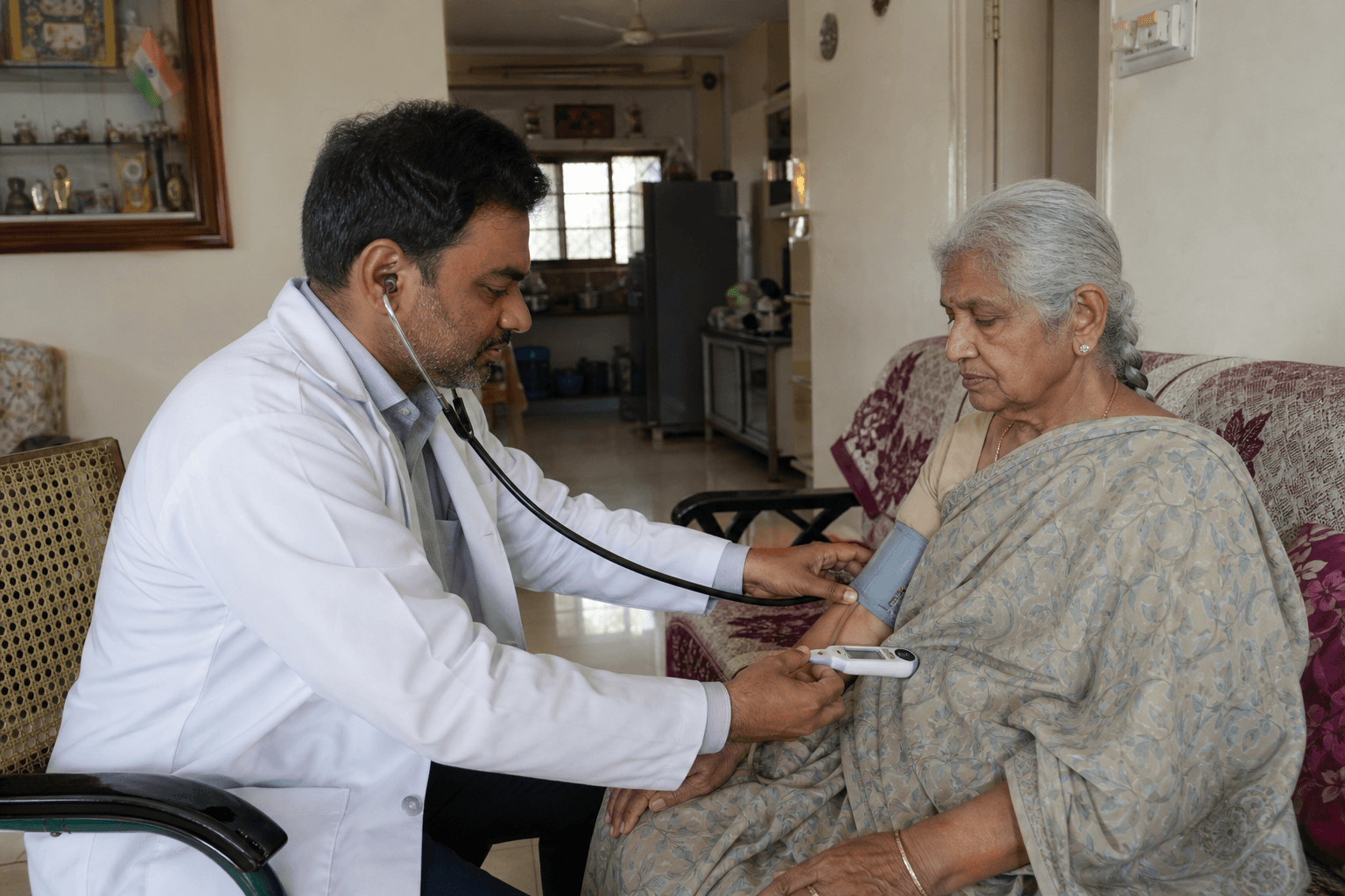 Indian doctor examining an elderly patient during a home visit in a Hyderabad apartment