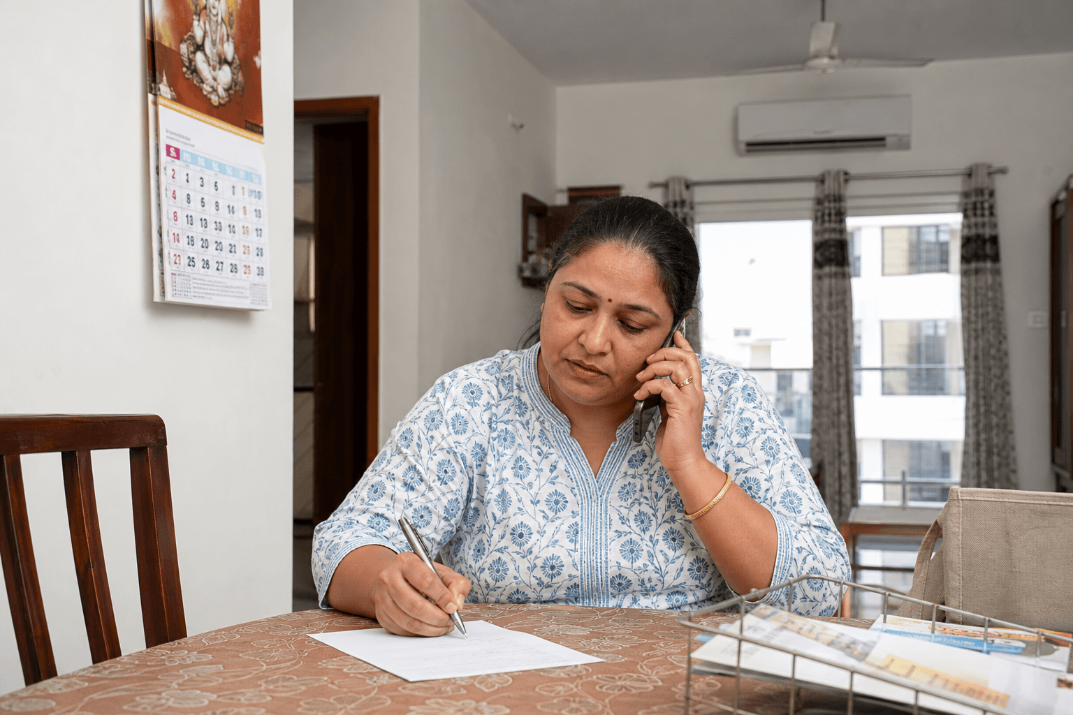 Indian family caregiver scheduling a home doctor visit time and address by phone
